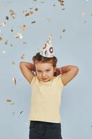 Happy little girl standing and have fun indoors at birthday party photo