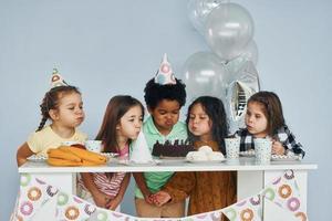 Holiday cake. Children on celebrating birthday party indoors have fun together photo