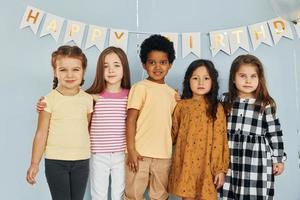 los niños que celebran la fiesta de cumpleaños en el interior se divierten juntos foto