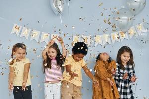 Children on celebrating birthday party indoors have fun together photo