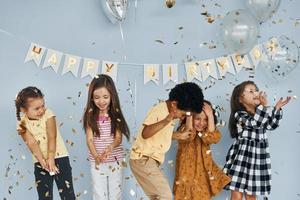 Children on celebrating birthday party indoors have fun together photo