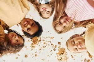 View from below. Children on celebrating birthday party indoors have fun together photo