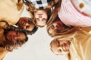 View from below. Children on celebrating birthday party indoors have fun together photo