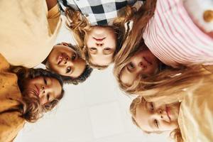 View from below. Children on celebrating birthday party indoors have fun together photo