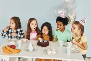 Holiday cake. Children on celebrating birthday party indoors have fun together photo