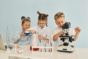 Test tubes with colorful liquid. Children in white coats plays a scientists in lab by using equipment photo