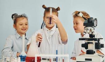 Test tubes with colorful liquid. Children in white coats plays a scientists in lab by using equipment photo