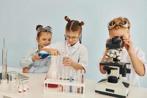 Test tubes with colorful liquid. Children in white coats plays a scientists in lab by using equipment photo