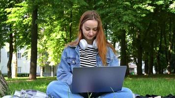 heureuse femme aux cheveux rouges utilisant un ordinateur portable pour l'apprentissage en ligne. concept de retour à l'école. éducation à distance dans le monde entier. début d'année scolaire video