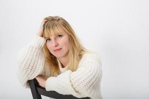 close up portrait of blonde girl model in white wool sweater on white background in studio photo