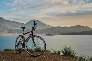 fethiye, turquía - 3 de diciembre de 2022. bicicleta en el fondo de la bahía, vista de la ciudad y las montañas circundantes. idea para un artículo sobre actividades al aire libre y cicloturismo foto