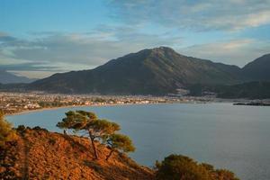 fethiye, turquía - 3 de diciembre de 2022. puesta de sol sobre la bahía de fethiye, vista de la ciudad y las montañas circundantes. invierno en el mar Egeo. idea de fondo foto