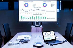 Mock up presentation on display television and laptop on table in meeting room photo