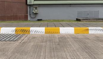 Yellow and white color curb stained with tires. photo