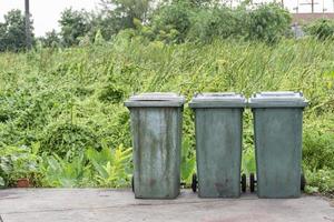 tres viejos cubos de basura verdes y fondo forestal con espacio para copiar foto