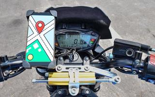 navegar por el mapa en la pantalla del teléfono inteligente en el manillar de la motocicleta foto