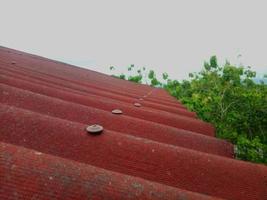 Closeup of red roof cover. Tiled roof with sky background photo