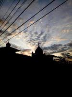 silueta de una mezquita al atardecer. cielo hermoso foto