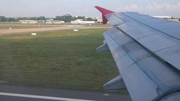 Flügelansicht aus der Flugzeugkabine während der niedrig fliegenden Landung zum Flughafen tagsüber