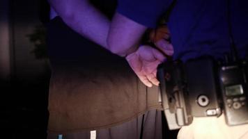 Polizist legt Verbrecher in Handschellen, um ihn zu verhaften - Straßenleben, Gesetz, Polizistenlichter video