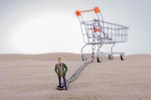 Man figurine attached to a Shopping cart photo