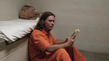 prisioneiro, homem bonito na cela lendo a bíblia, encarcerado, cadeia video