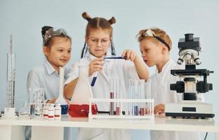 Test tubes with colorful liquid. Children in white coats plays a scientists in lab by using equipment photo