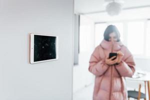 control climatico. la mujer joven está adentro en la habitación de la casa inteligente durante el día foto