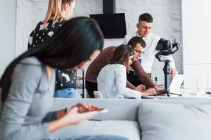 Crew of photographers and models is indoors in the modern room photo