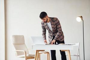 trabaja en la oficina. joven y elegante hombre de negocios con traje en el interior. concepción del éxito foto