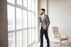 trabaja en la oficina. joven y elegante hombre de negocios con traje en el interior. concepción del éxito foto