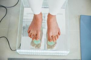 Woman standing on the scanner of feet. Conception of healthcare photo