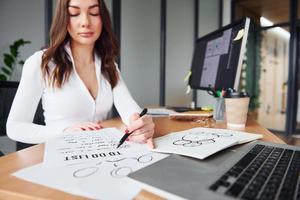 Young adult woman in formal clothes is indoors in the office photo