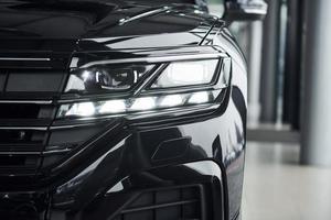 Particle close up view of modern new black automobile that parked indoors photo