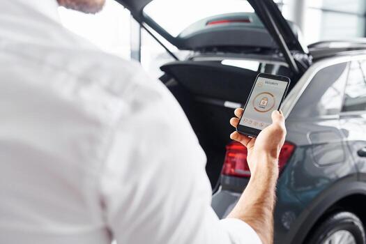 Close up view of man's hand that holds phone with labels and icons. Conception of remote control photo