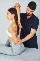 Girl is sitting. Physiotherapist works with young woman indoors in the spa photo