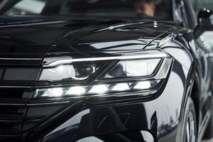 Particle close up view of modern new black automobile that parked indoors photo