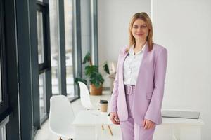 mujer con ropa formal está en el interior de la oficina moderna durante el día foto