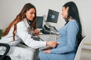 Another consultation. Pregnant woman is in the clinic in cabinet and have health check photo