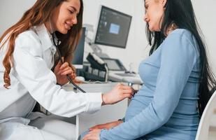 Another consultation. Pregnant woman is in the clinic in cabinet and have health check photo