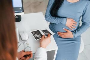 Another consultation. Pregnant woman is in the clinic in cabinet and have health check photo