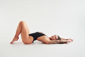 vista lateral. hermosa mujer deportiva seductora con cuerpo sexy está posando en el estudio foto