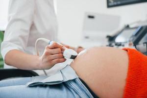 diagnóstico por ultrasonido. la mujer embarazada está en la clínica en el gabinete y tiene un control de salud