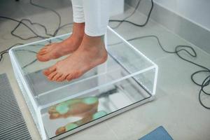 Woman standing on the scanner of feet. Conception of healthcare photo