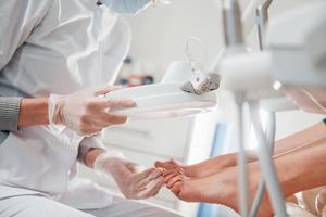 Woman lying down and have operation on her feet by professional clinic worker photo