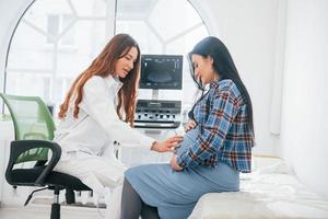 Pregnant woman is in the clinic in cabinet and have health check photo