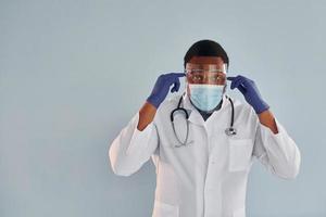 African american doctor in white coat is standing indoors photo