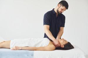 Head massage. Young woman is lying down when man doing procedure to her in spa photo