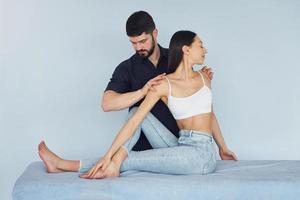 Girl is sitting. Physiotherapist works with young woman indoors in the spa photo