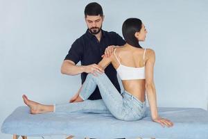 Girl is sitting. Physiotherapist works with young woman indoors in the spa photo